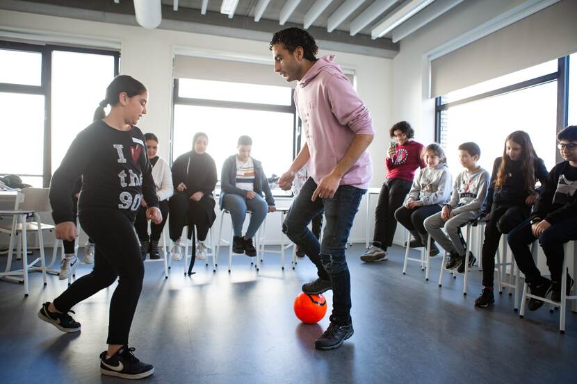 Soufiane Touzani voetbalt samen met een leerling