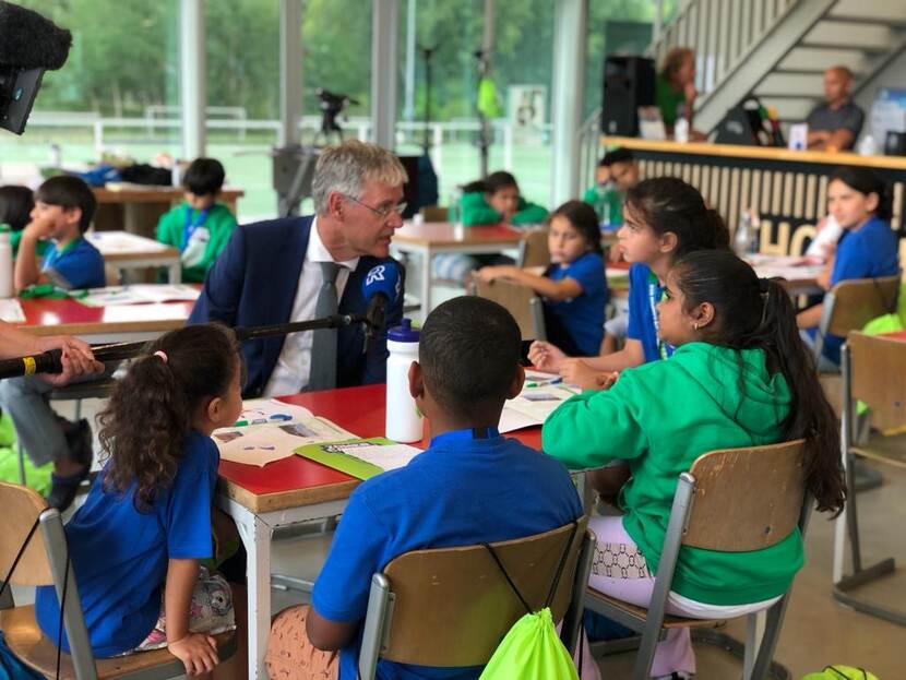 Minister Slob praat met leerlingen die deelnemen aan de Zomercampus010