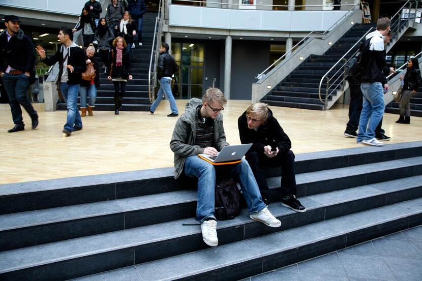 Studenten zitten op de trap in het schoolgebouw