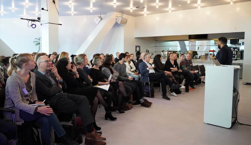 Luisterend publiek tijdens een presentatie op het symposium